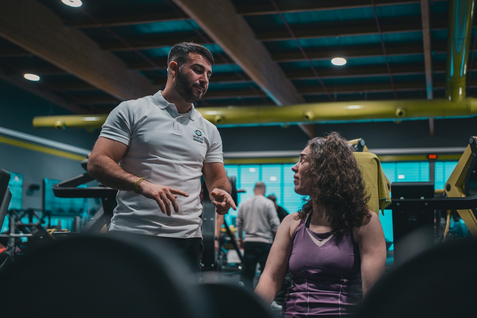 The coach talking with a client between sets in the gym