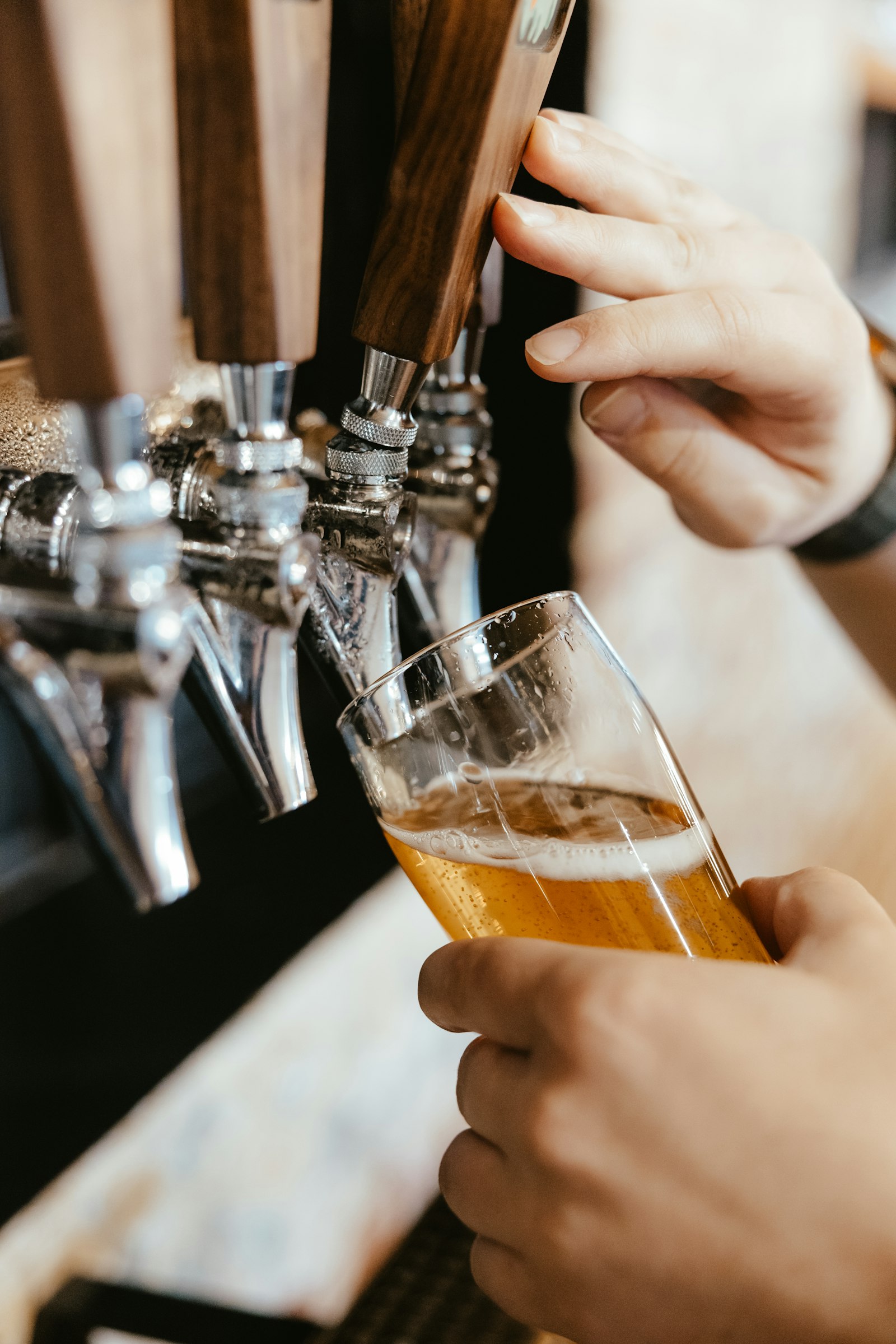 A hand pulling a tap into a glass