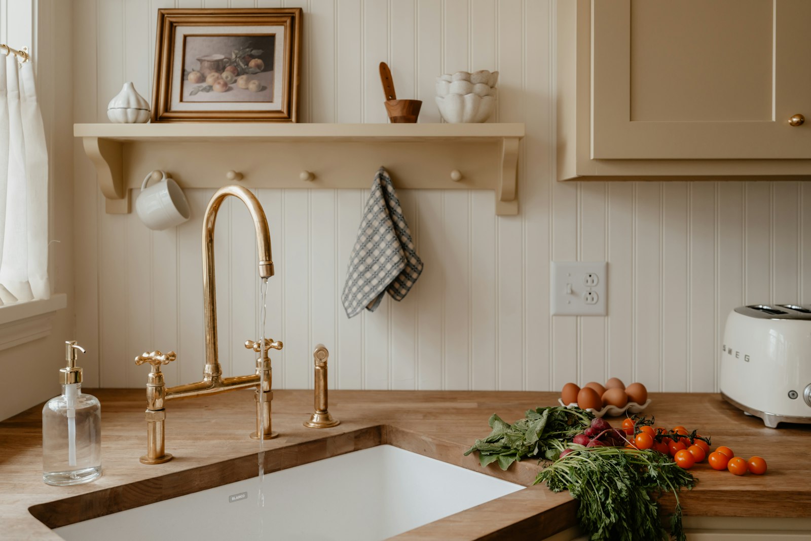 A farmhouse kitchen with a Belfast sink and a brass tap