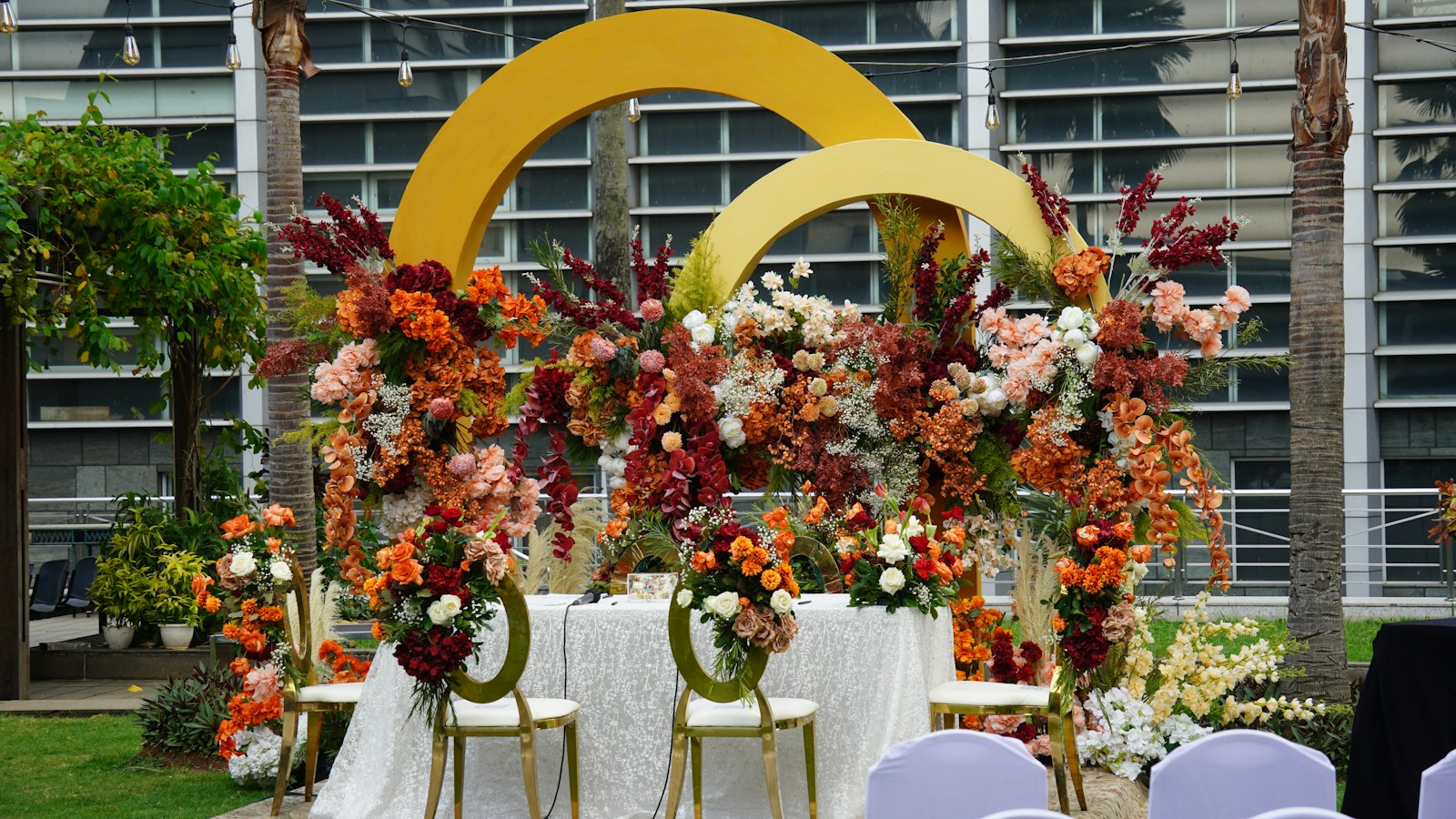 A floral installation with gold hoops over a head table