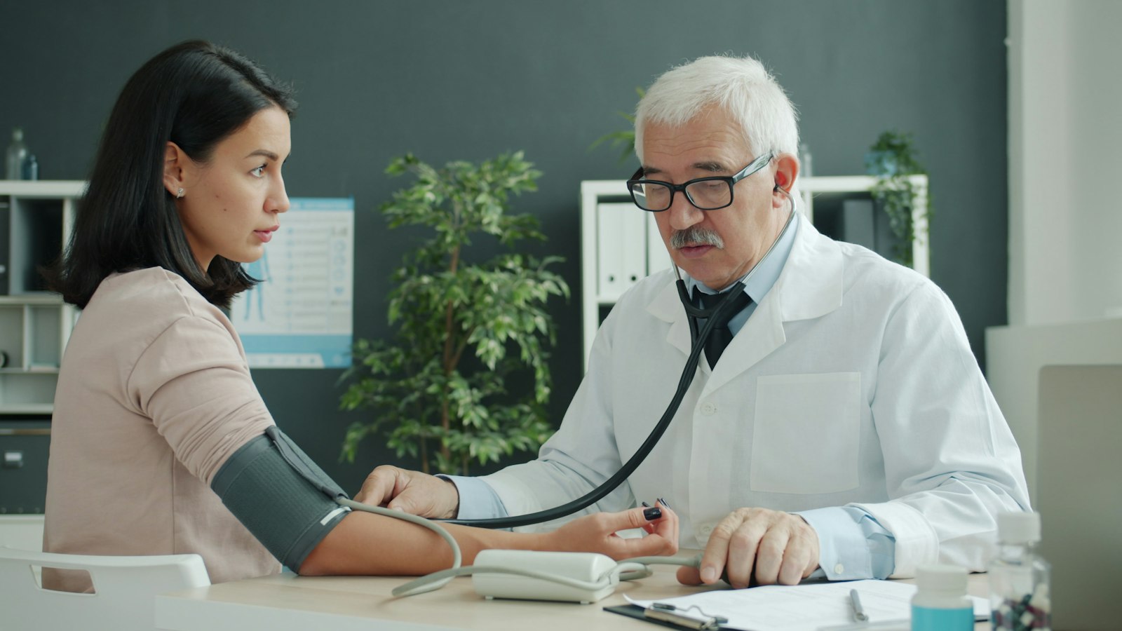 A doctor checking a patient's blood pressure