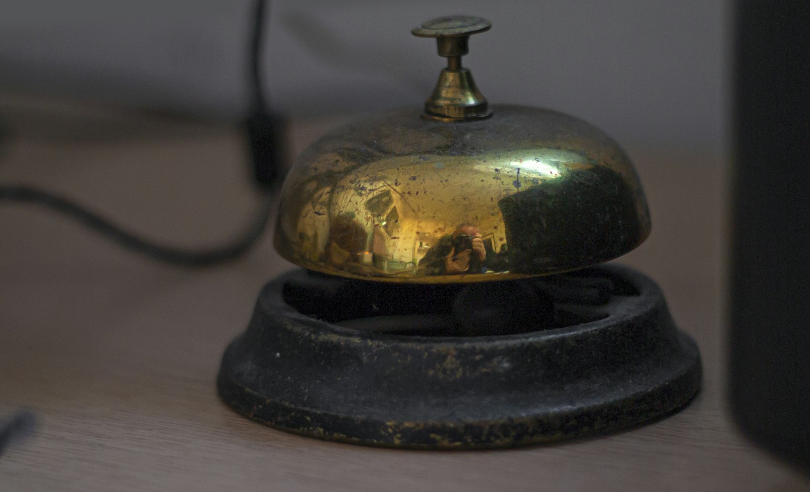A brass reception bell on a desk