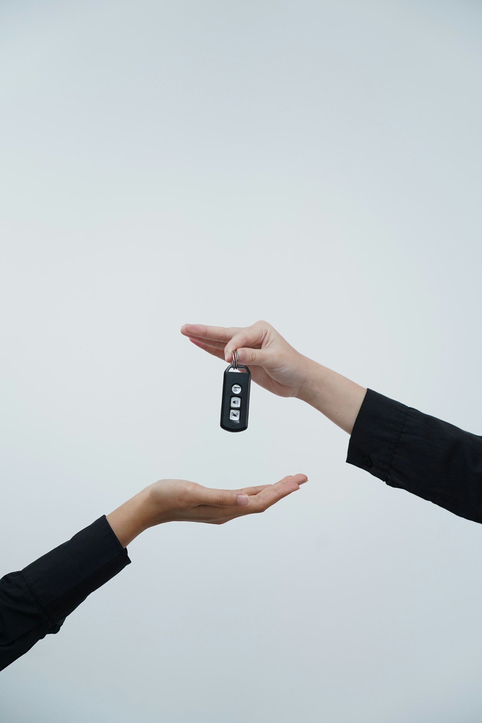 One hand passing a car key to another