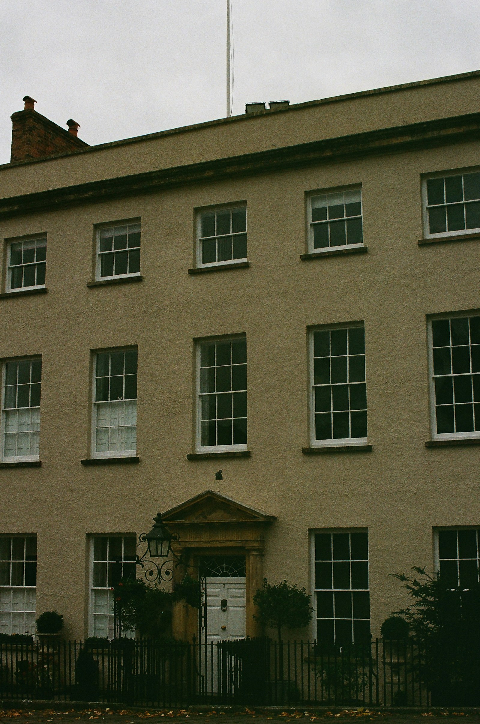 A three-storey Georgian townhouse with railings and a central door