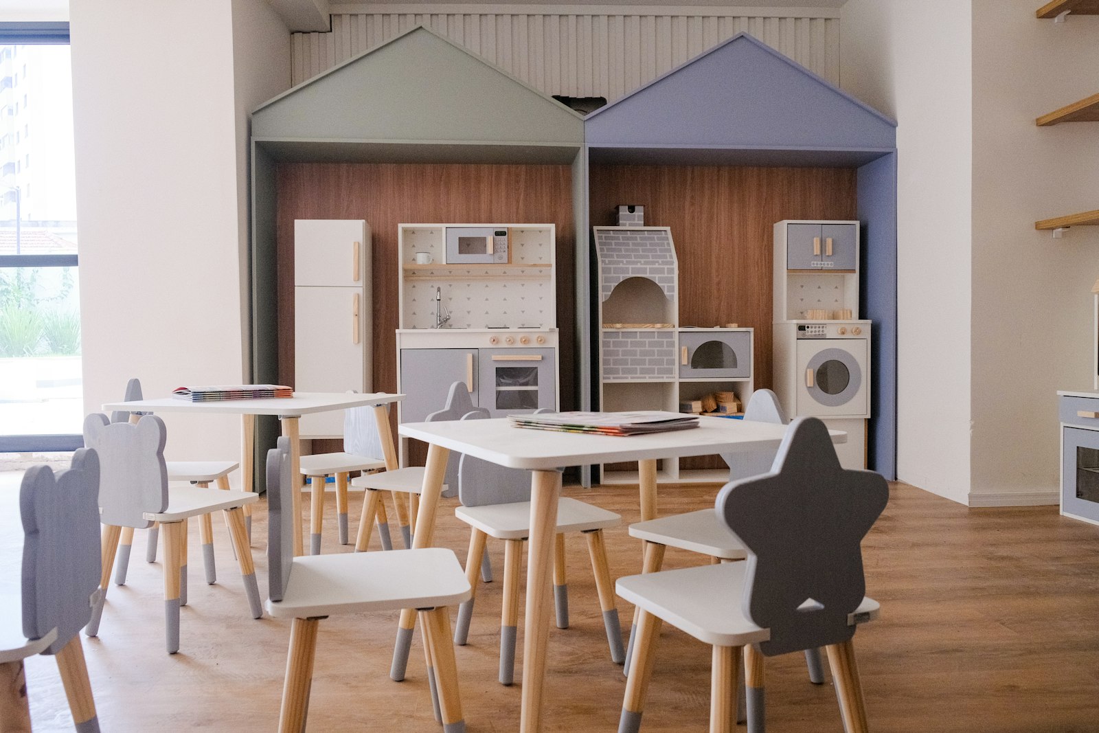 A play-kitchen corner with small tables and chairs