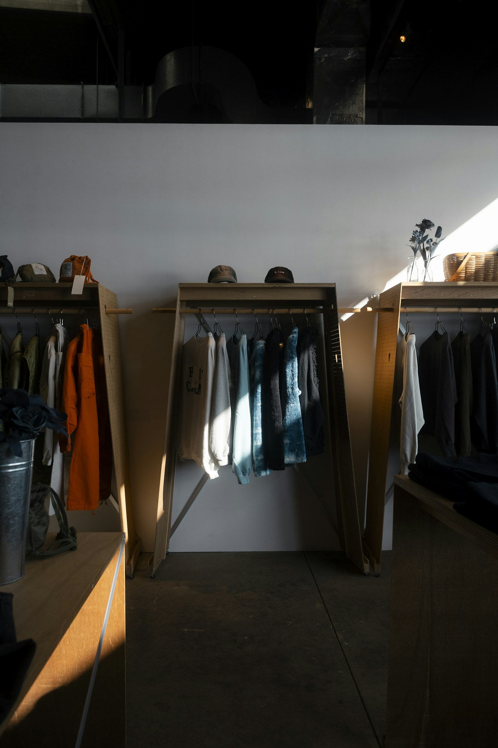 Sunlit wooden rails of shirts and jackets in an independent shop
