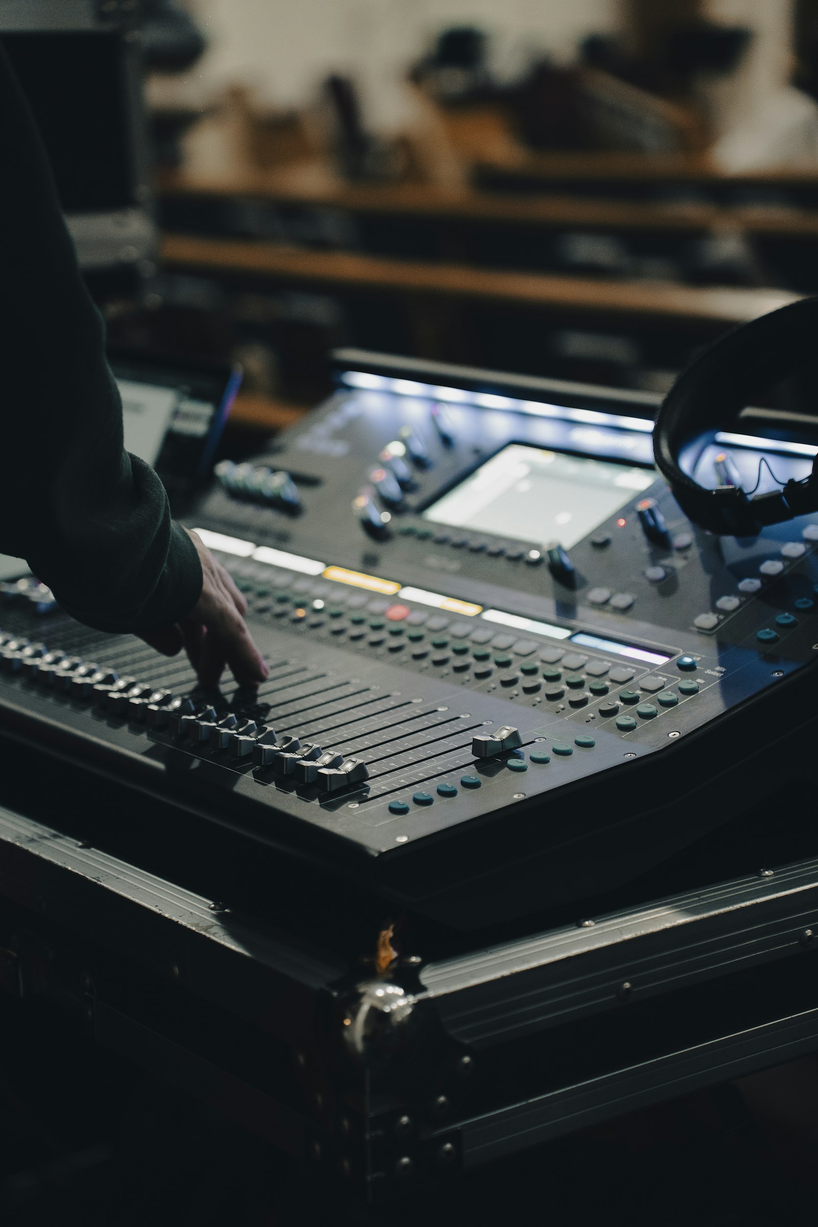 A technician's hand on a sound mixing desk
