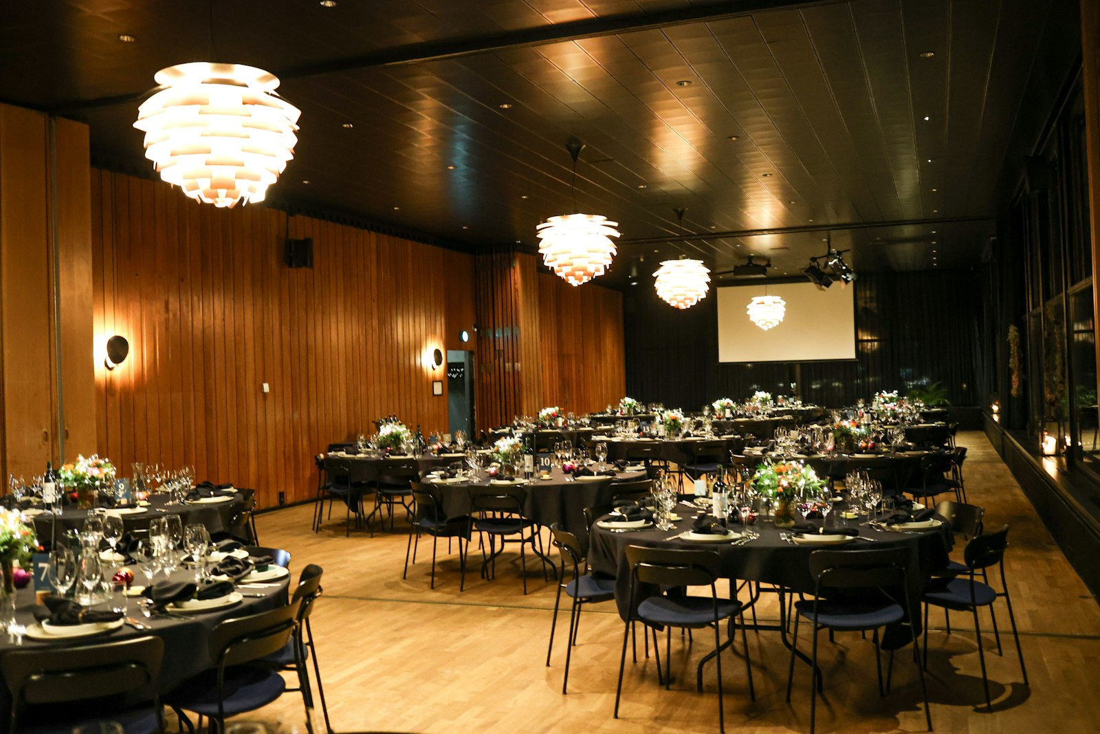 Round dinner tables in a wood-panelled room