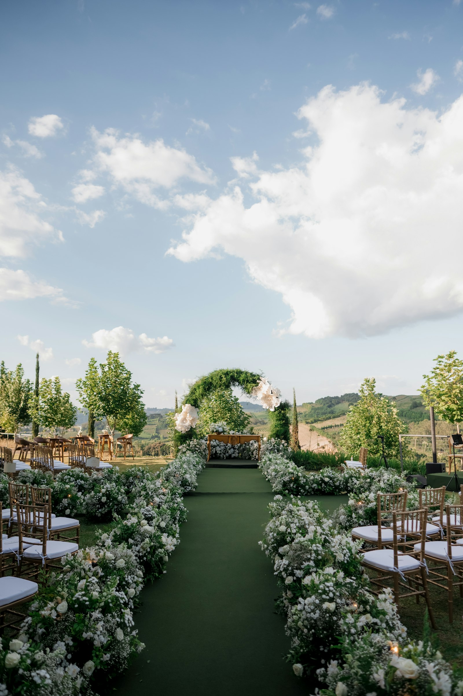 A garden ceremony aisle lined with white flowers