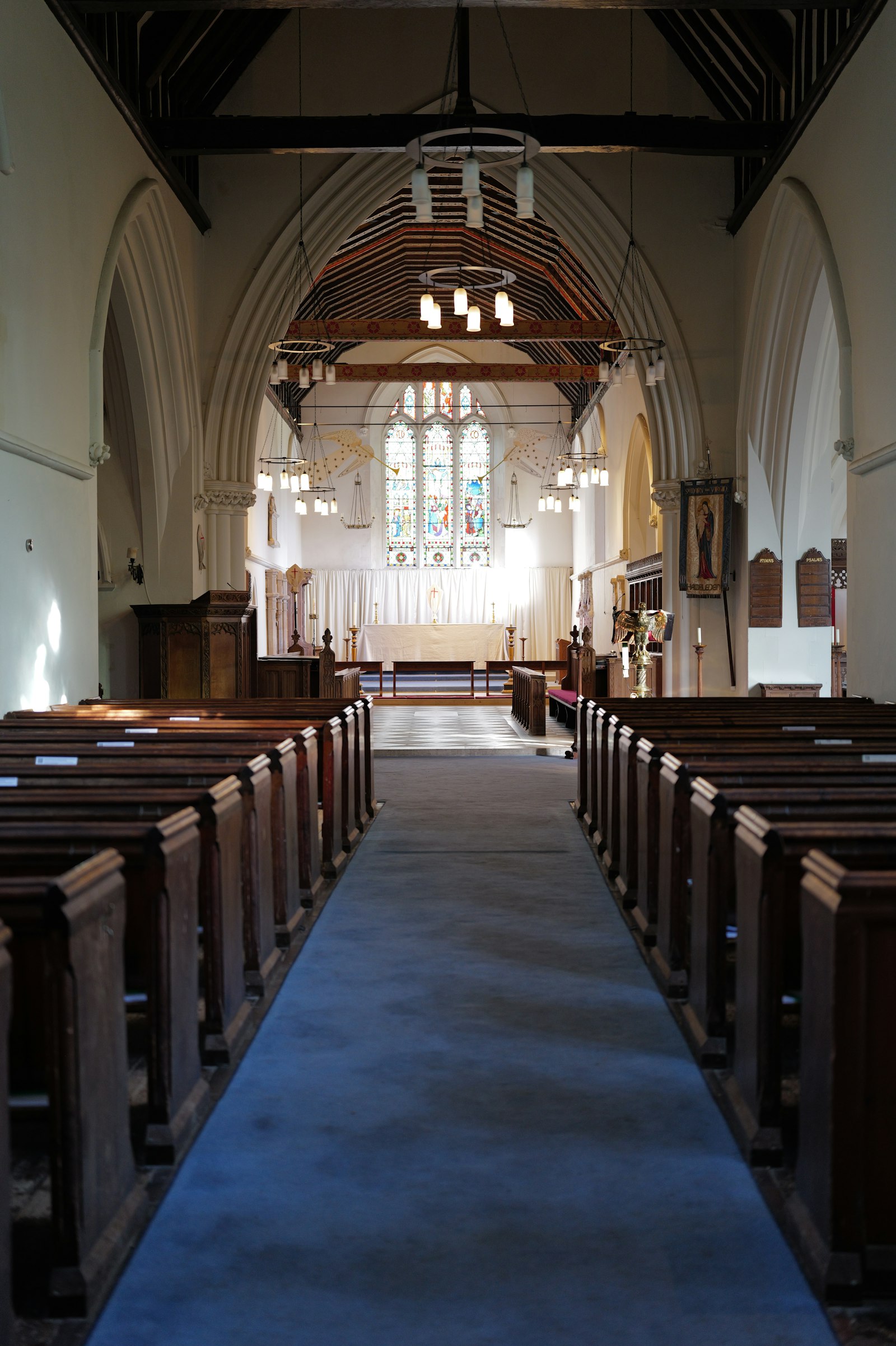 The nave with dark pews leading to the east window