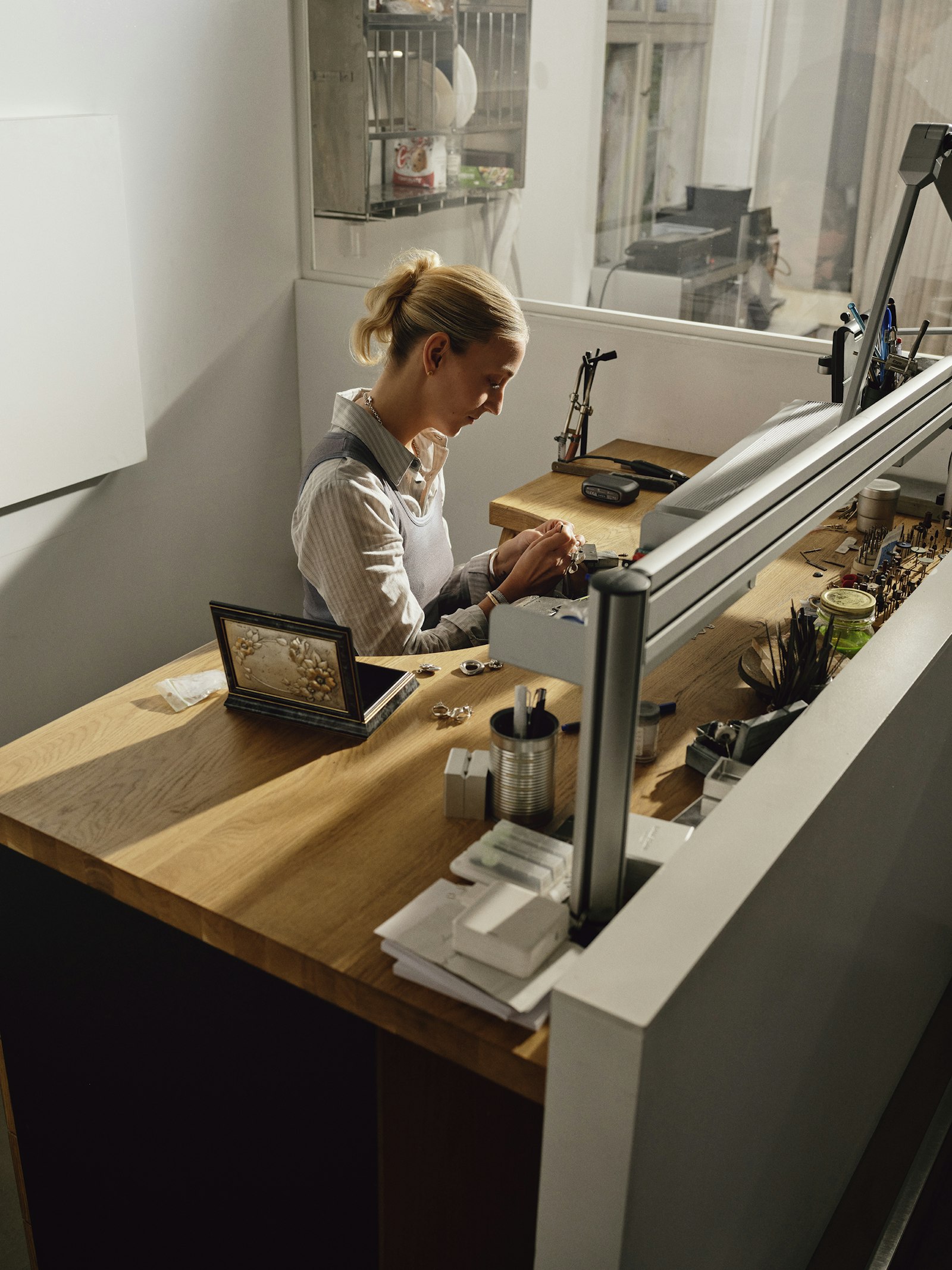 A woman working at an oak jeweller's bench