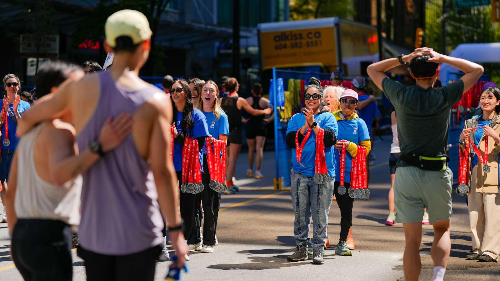 Finishers with medals round their necks and a supporter cheering