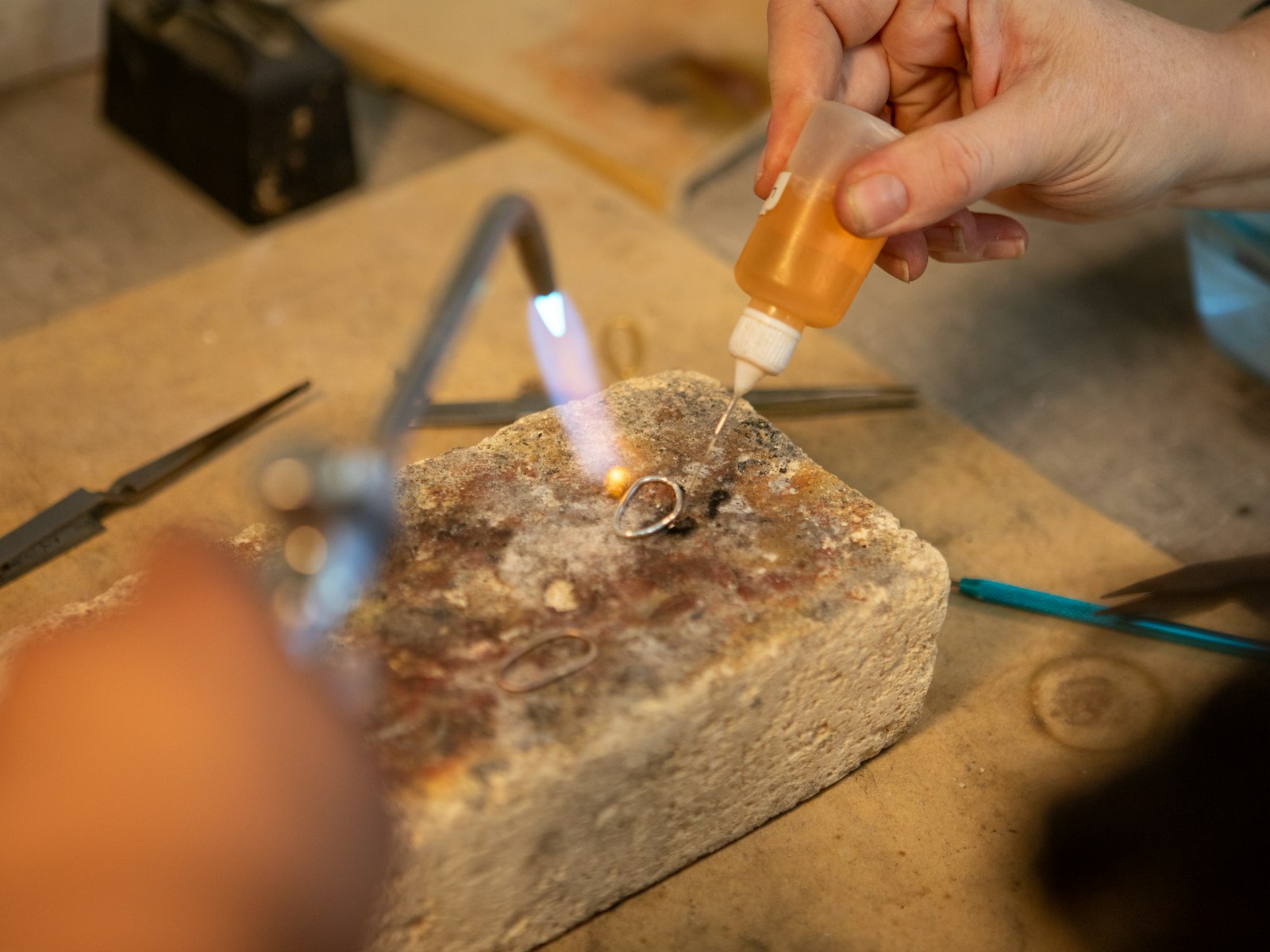 A jeweller soldering a ring with a torch