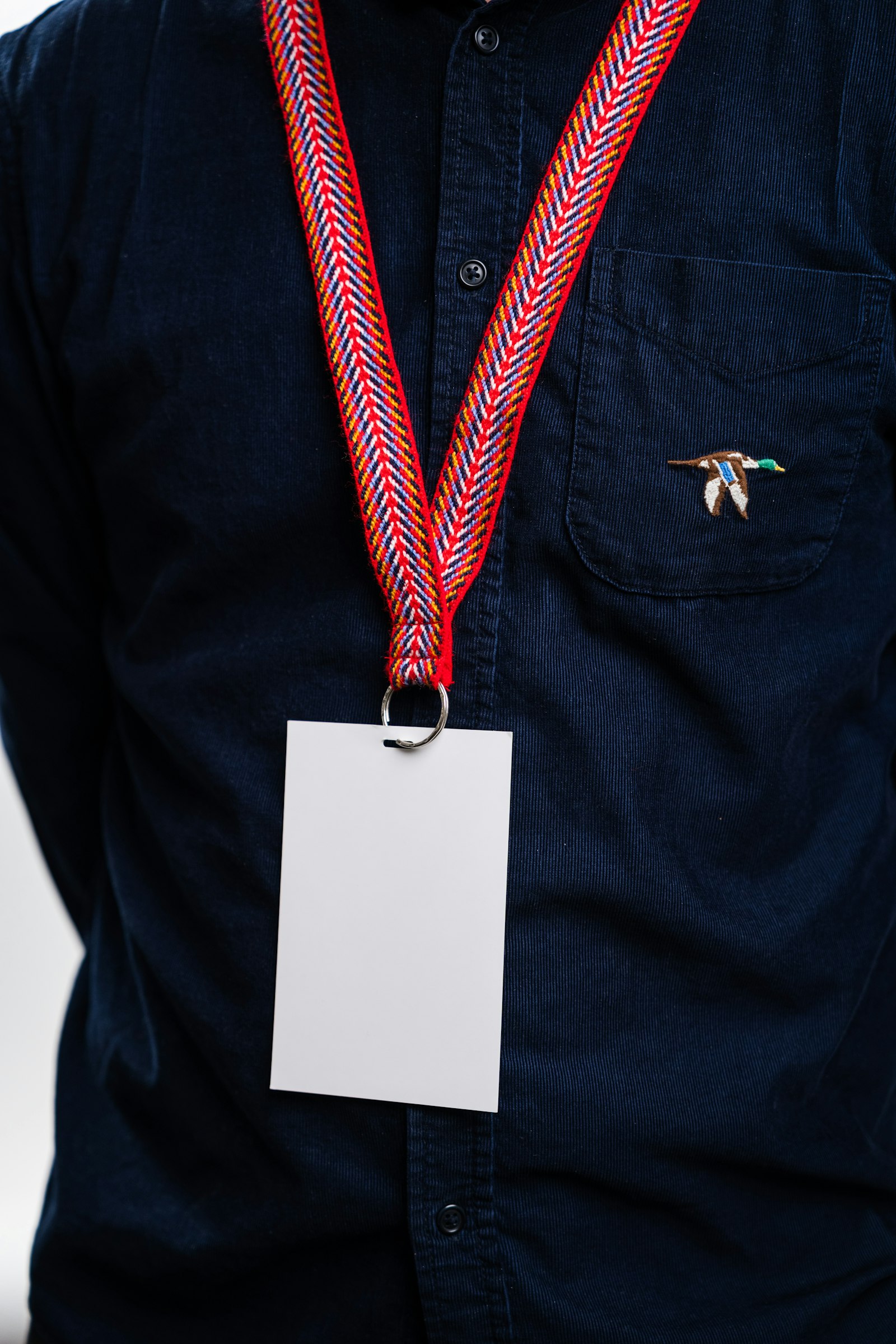 A name badge on a patterned lanyard