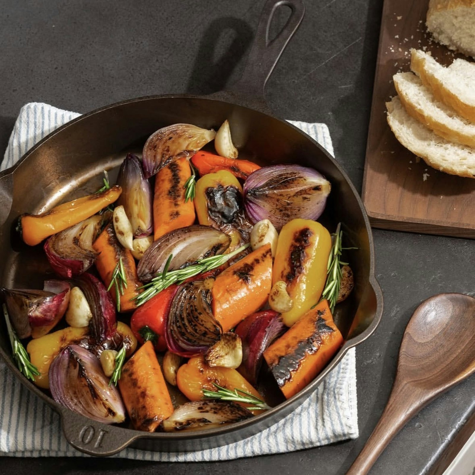 Charred peppers and carrots in a cast-iron skillet