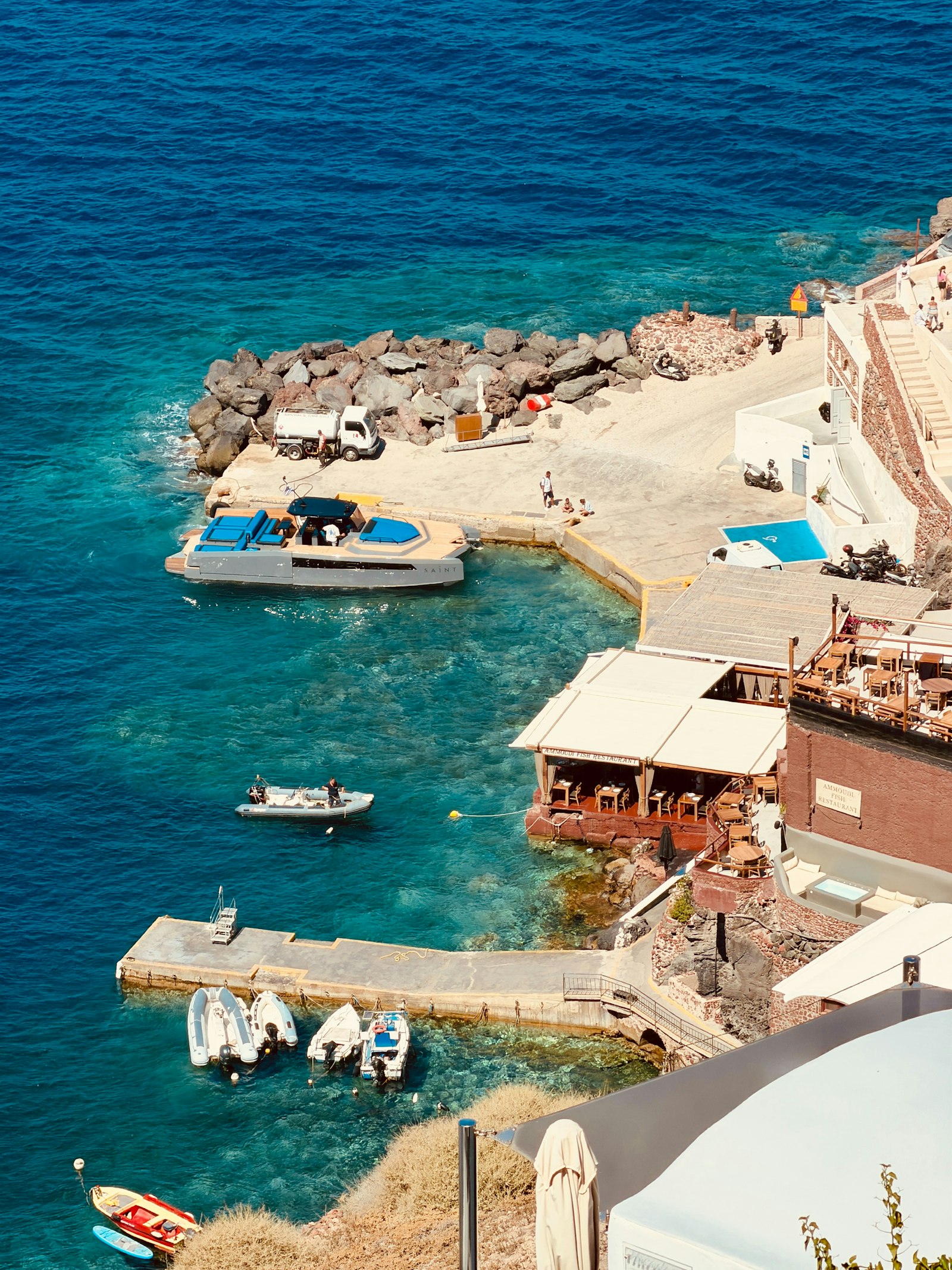 An aerial view of a Santorini bay with boats