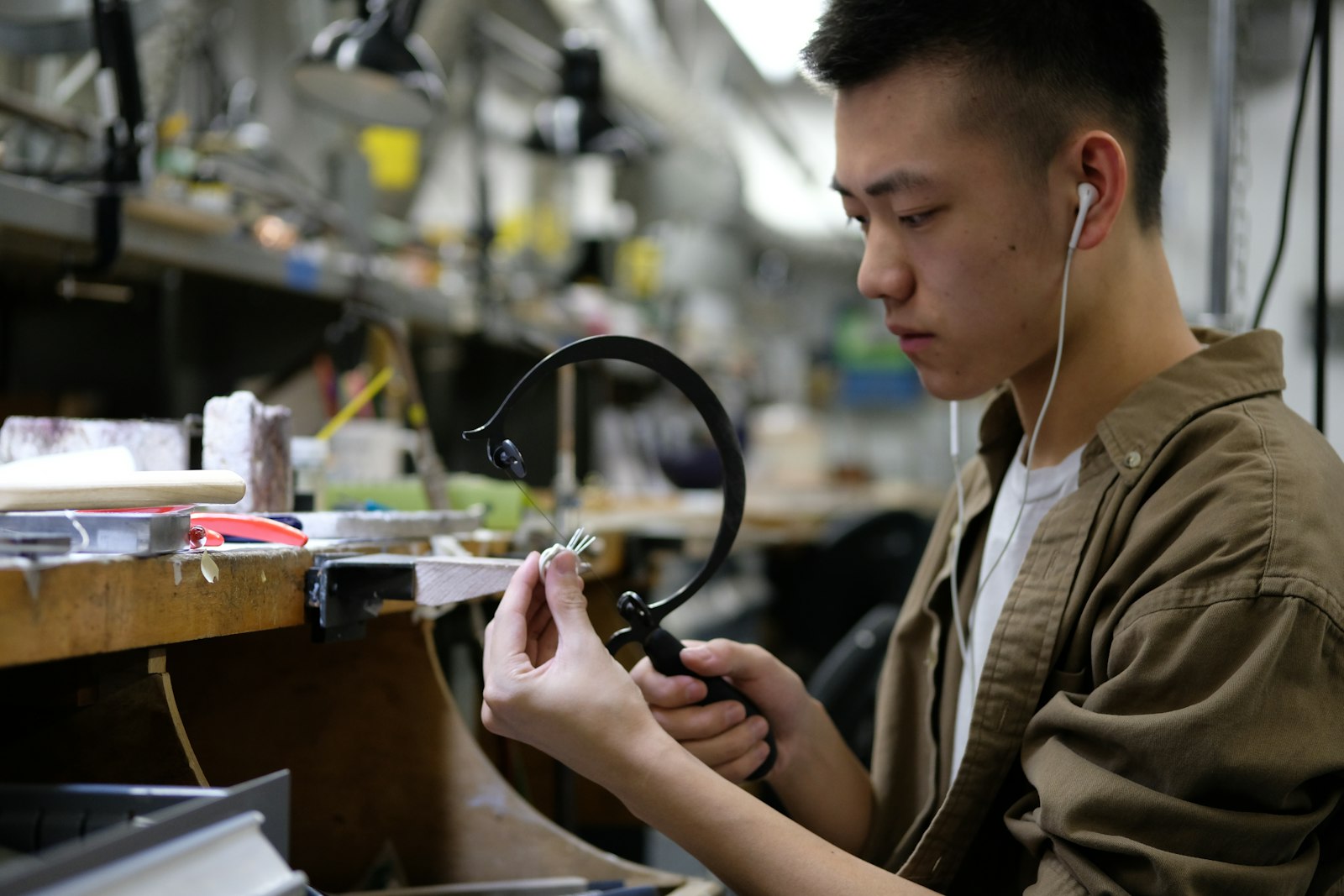A jeweller at the bench with a piercing saw