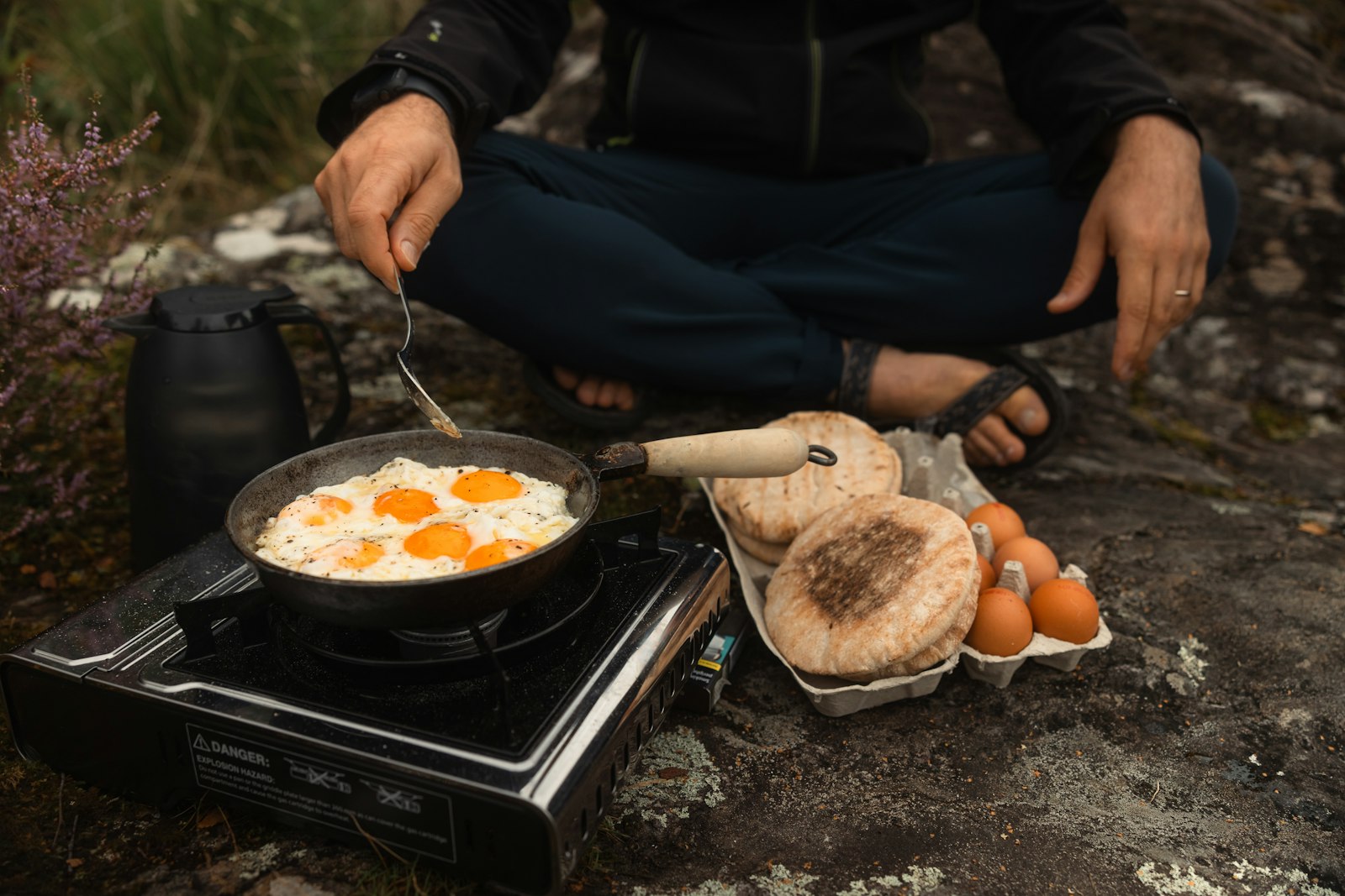 Eggs frying on a camping stove on a rock
